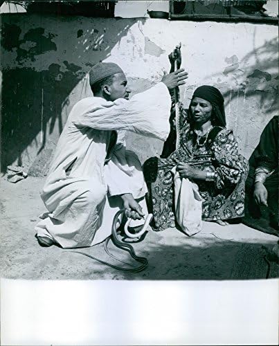 Гроздобер фотографија на луѓе кои држат змии во Абу Раваш, Египет, 1964 година.